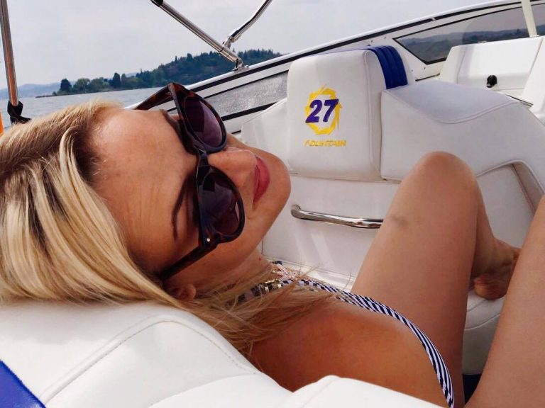 blonde Frau im Bikini auf Motorboot